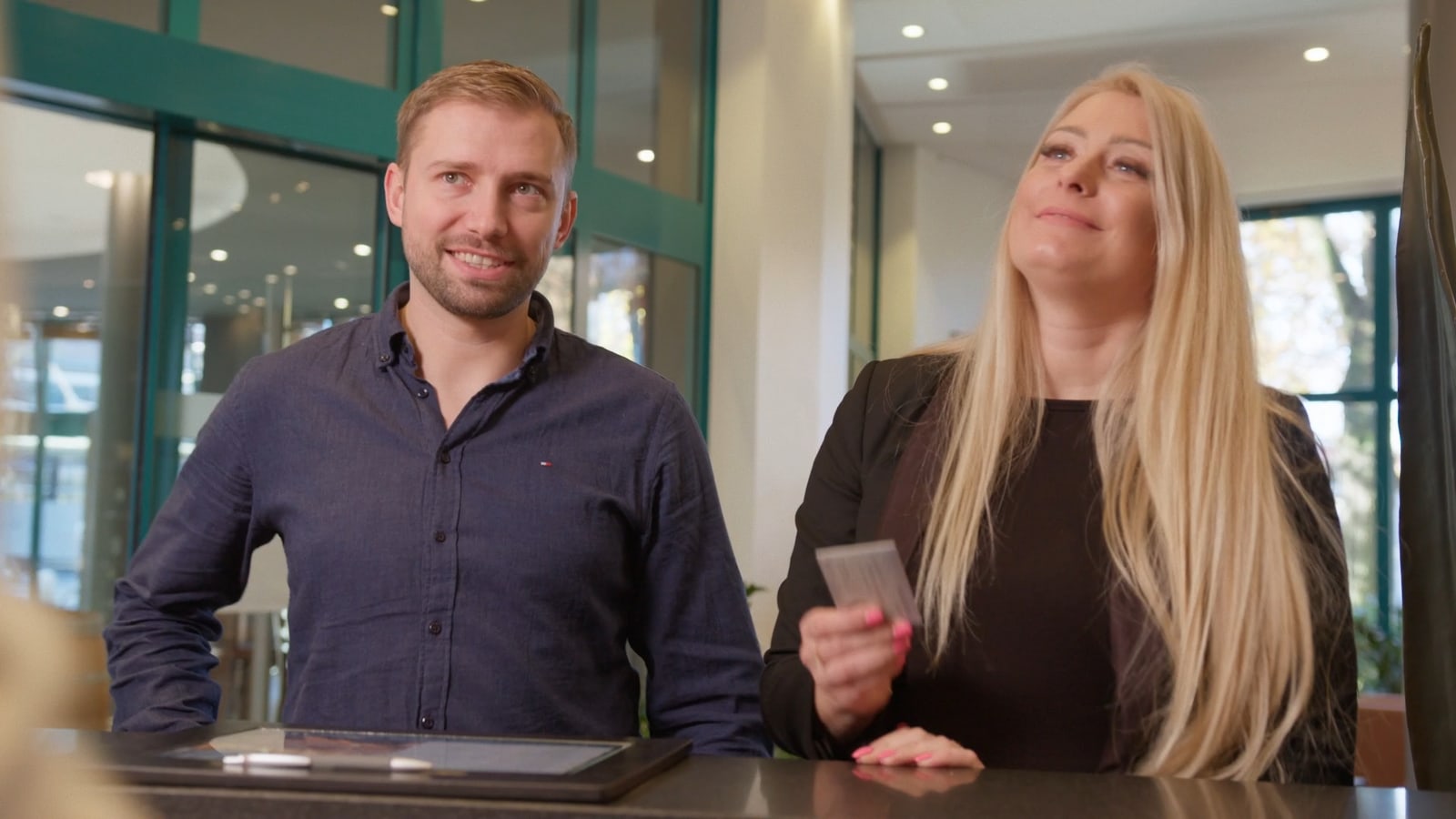 Check-in-Situation mit Gästen im ATLANTIC Hotel Airport Bremen.