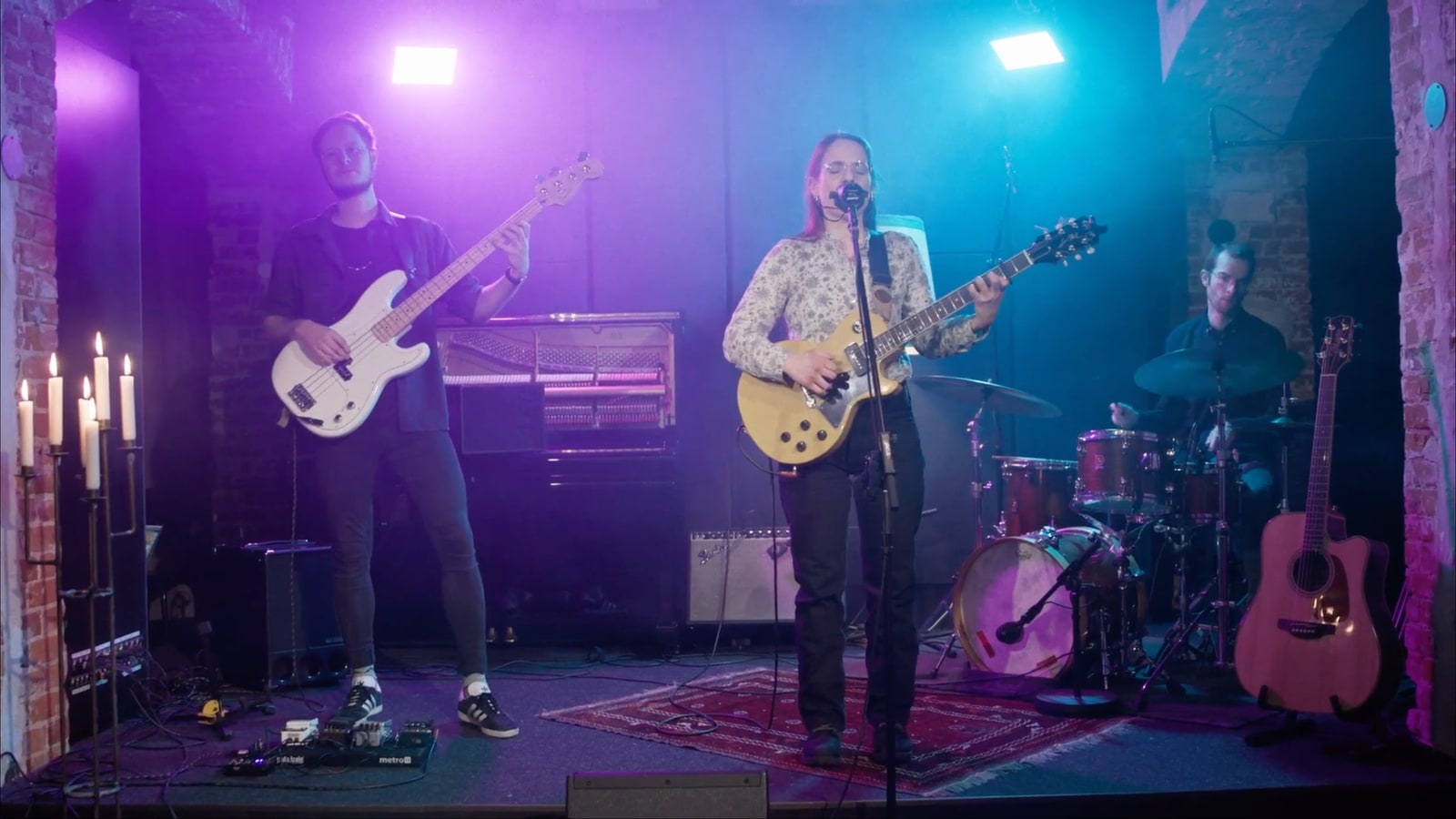 Still from live recording sessions with band, magenta-cyan lighting and a controlled setup.