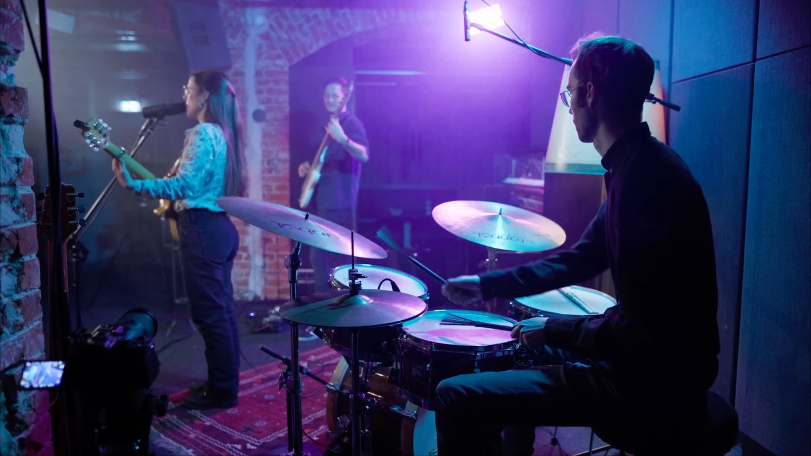 Drummer perspective from the live recording sessions with singer, bass and controlled lighting.