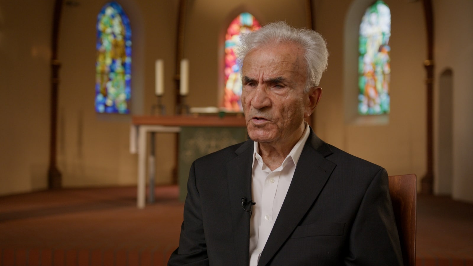 Still from a documentary witness interview inside a church.